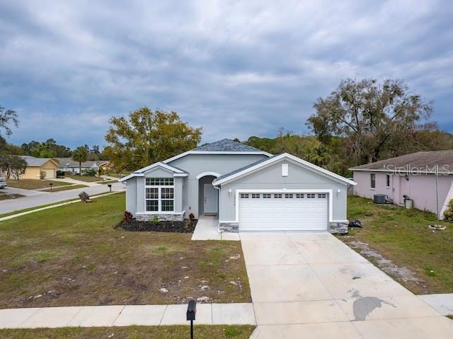 ranch-style home with a garage, a front yard, driveway, and stucco siding