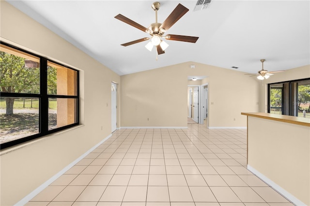 unfurnished room with visible vents, baseboards, ceiling fan, lofted ceiling, and light tile patterned flooring