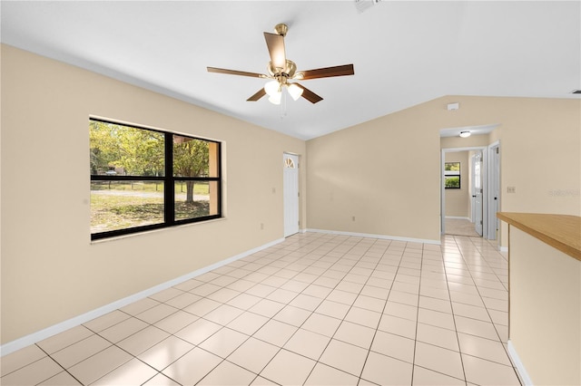 unfurnished room with light tile patterned floors, baseboards, lofted ceiling, and ceiling fan