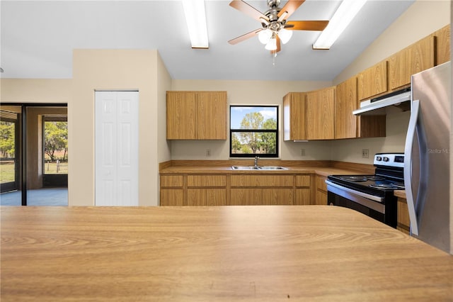 kitchen with freestanding refrigerator, a sink, electric range oven, light countertops, and under cabinet range hood