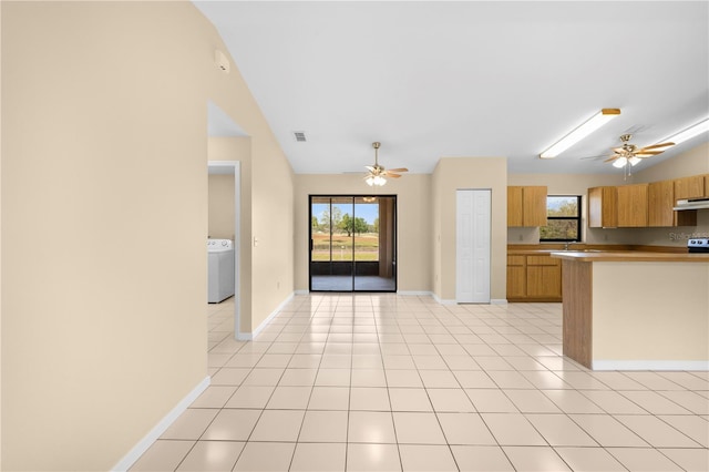 kitchen featuring washer / dryer, light tile patterned flooring, a ceiling fan, and under cabinet range hood