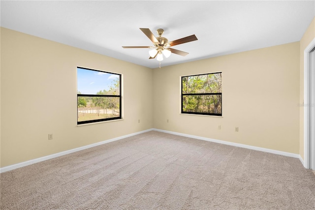 unfurnished room featuring a ceiling fan, baseboards, and light carpet