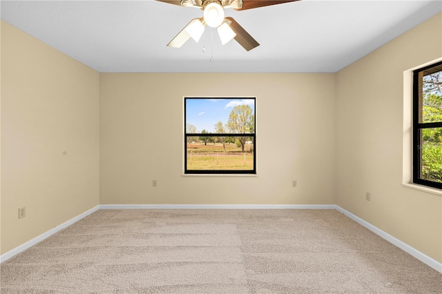 spare room with baseboards, carpet, and a ceiling fan