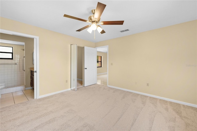 unfurnished bedroom featuring light tile patterned floors, baseboards, visible vents, light carpet, and connected bathroom