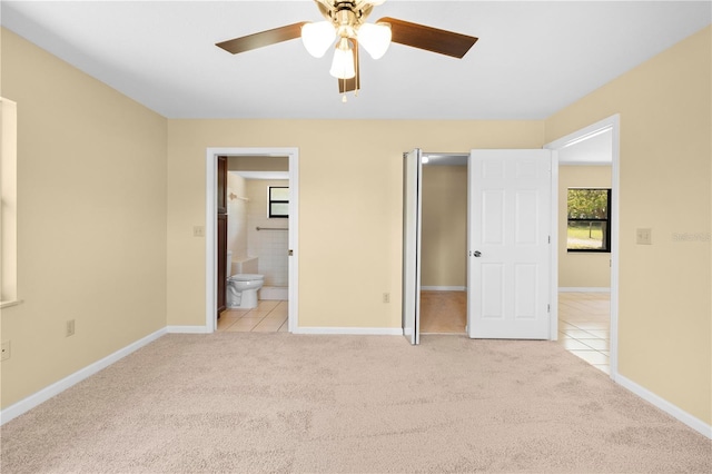 unfurnished bedroom featuring light carpet, light tile patterned floors, ensuite bathroom, and baseboards