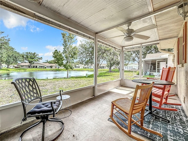 sunroom / solarium featuring a water view and a ceiling fan