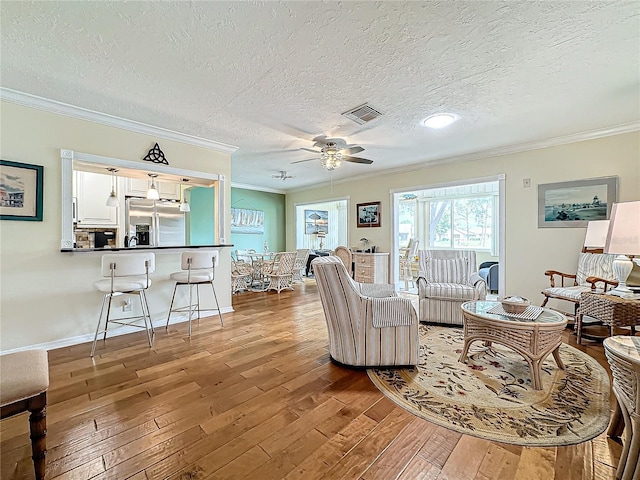 living room featuring crown molding, ceiling fan, and hardwood / wood-style floors