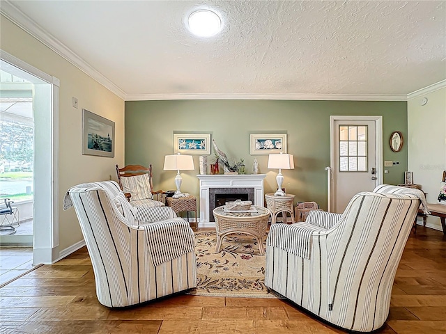 living room with hardwood / wood-style floors, a textured ceiling, a fireplace, and ornamental molding