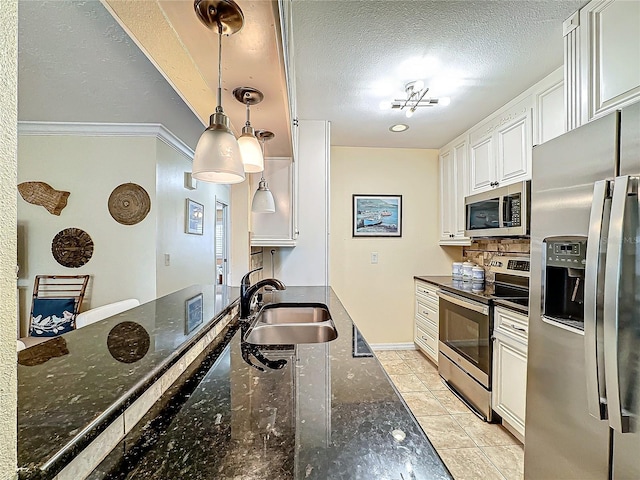 kitchen featuring a sink, dark stone countertops, a textured ceiling, appliances with stainless steel finishes, and white cabinets