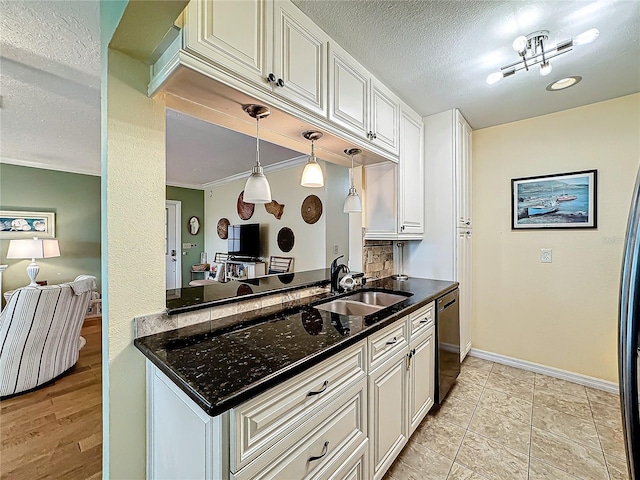 kitchen with baseboards, dishwashing machine, white cabinets, a textured ceiling, and a sink