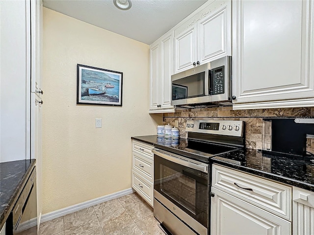 kitchen featuring baseboards, light tile patterned floors, decorative backsplash, white cabinets, and stainless steel appliances