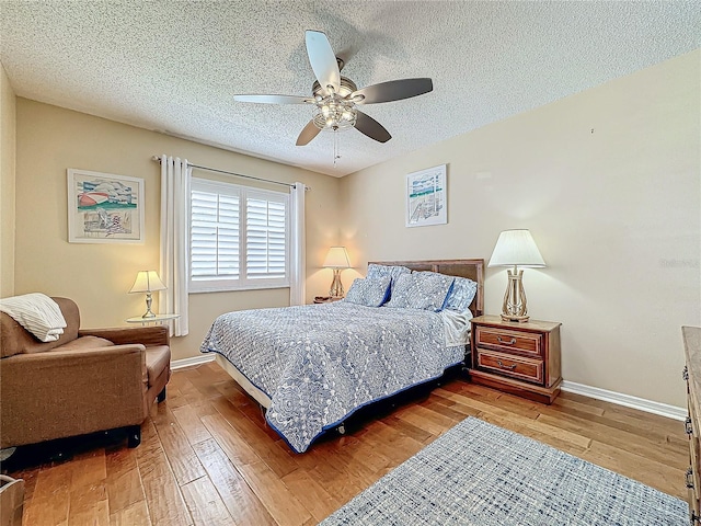 bedroom with baseboards, wood-type flooring, and a textured ceiling