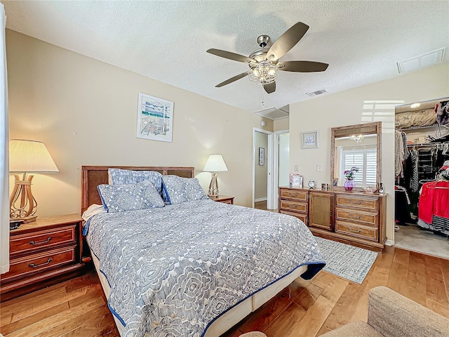 bedroom featuring visible vents, wood-type flooring, a textured ceiling, and a closet