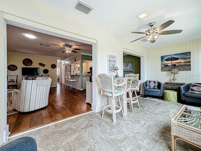 interior space featuring visible vents, ceiling fan, and ornamental molding