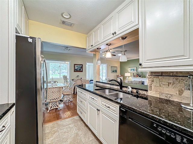 kitchen with visible vents, dishwasher, freestanding refrigerator, white cabinets, and a sink