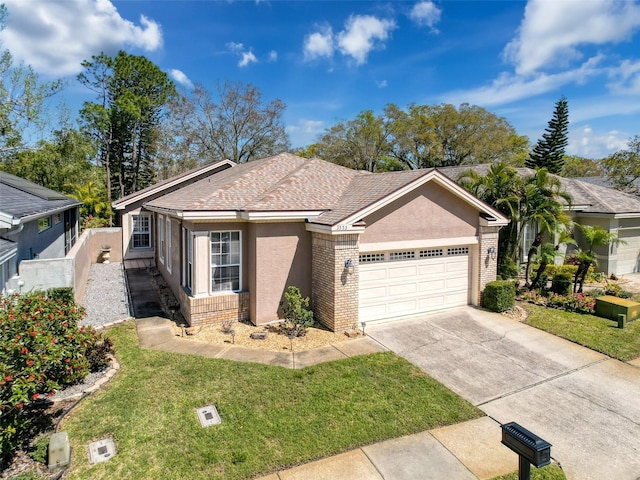 ranch-style house with stucco siding, concrete driveway, a front lawn, a garage, and brick siding