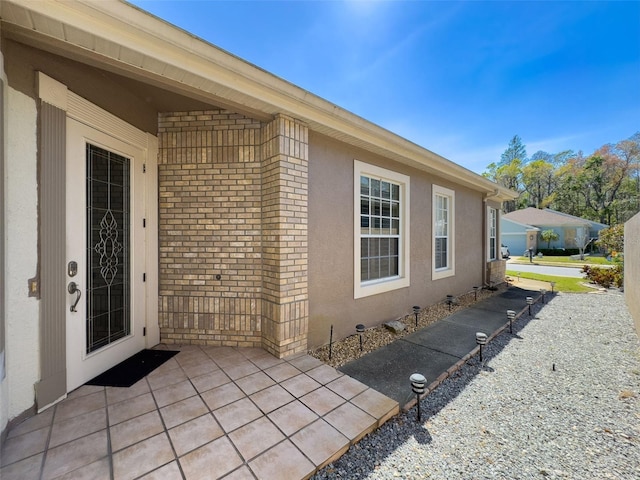 exterior space featuring stucco siding, a patio, and brick siding