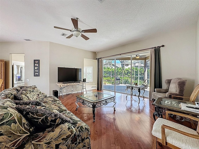 living area featuring ceiling fan, visible vents, and wood finished floors