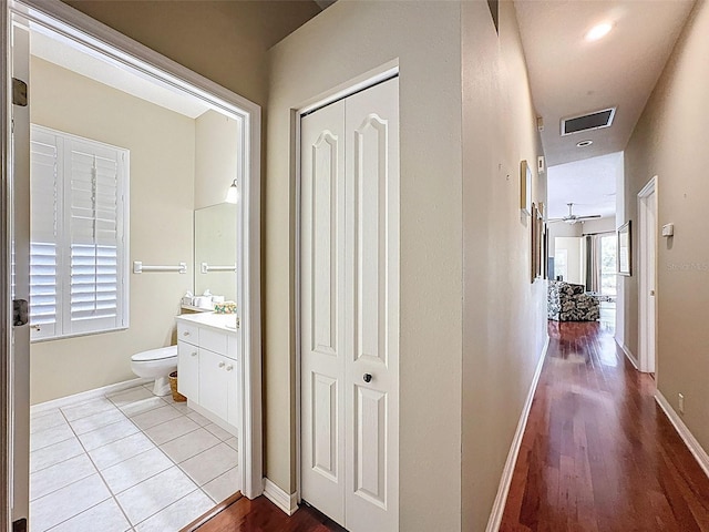 hall featuring tile patterned flooring, baseboards, and visible vents