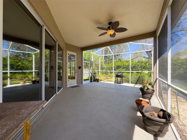 unfurnished sunroom with ceiling fan