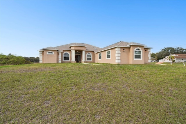 view of front facade with stucco siding and a front yard