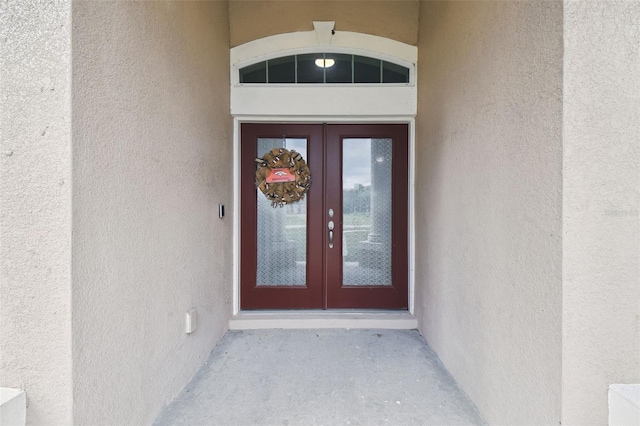 doorway to property featuring french doors and stucco siding