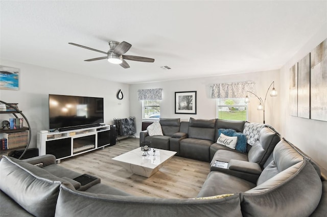 living room featuring visible vents, wood finished floors, and a ceiling fan