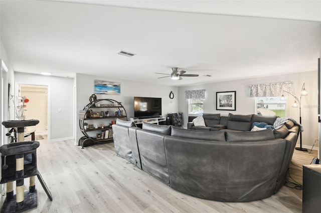 living area with visible vents, ceiling fan, baseboards, and light wood-style floors