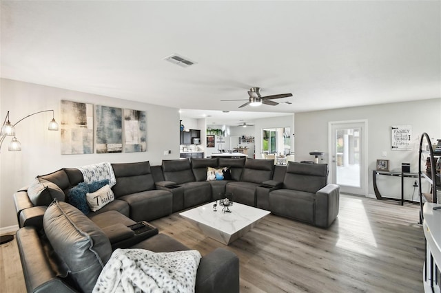 living room featuring visible vents, ceiling fan, baseboards, and light wood-style floors