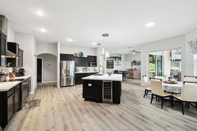 kitchen with a sink, wine cooler, dark cabinetry, and stainless steel refrigerator with ice dispenser