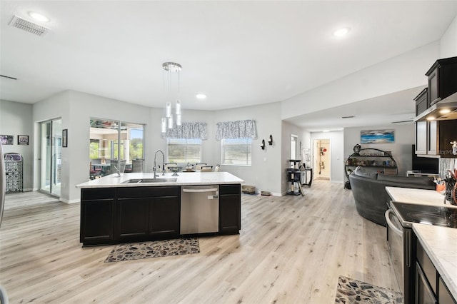 kitchen with stainless steel dishwasher, dark cabinetry, visible vents, and a sink