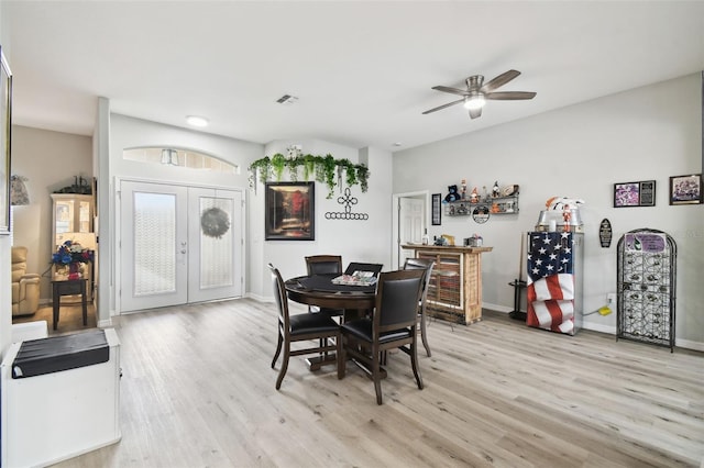 dining area with visible vents, baseboards, ceiling fan, light wood-style floors, and french doors