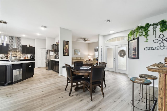 dining space with ceiling fan, french doors, visible vents, and light wood-type flooring