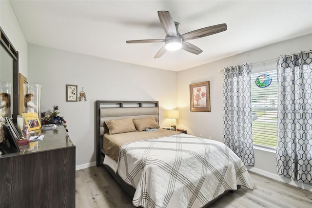 bedroom with light wood-type flooring, baseboards, and a ceiling fan