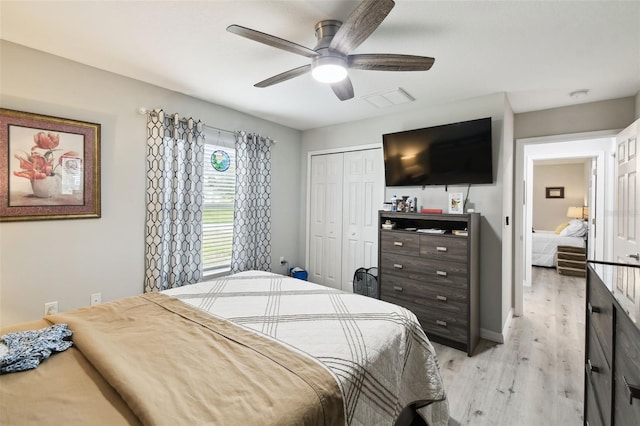 bedroom with baseboards, visible vents, light wood-style flooring, ceiling fan, and a closet