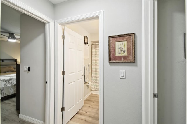 hallway with light wood-style flooring and baseboards