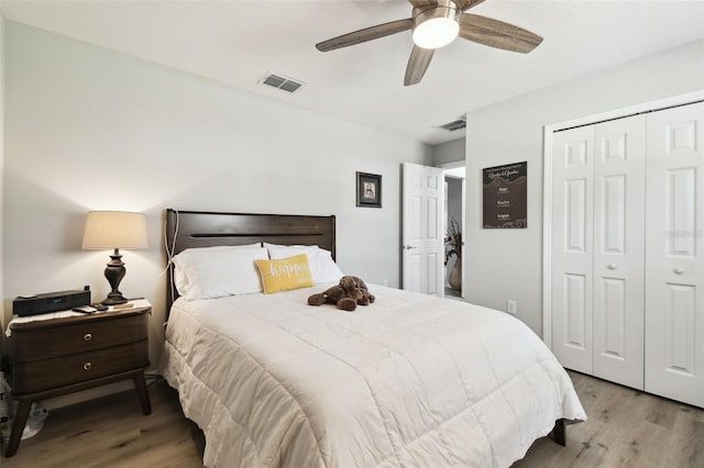 bedroom with visible vents, a closet, wood finished floors, and a ceiling fan