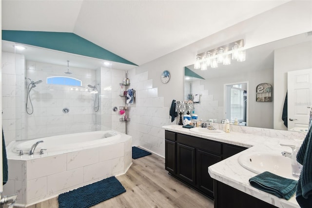 bathroom with double vanity, wood finished floors, lofted ceiling, and a sink