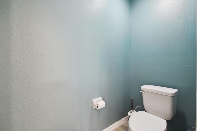 bathroom with toilet and baseboards