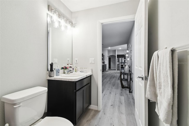 bathroom featuring vanity, toilet, and wood finished floors