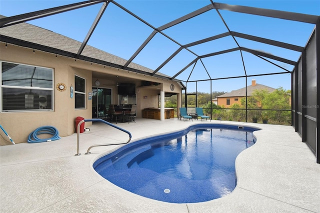 pool with glass enclosure and a patio area