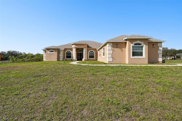 view of front facade with a front yard and stucco siding