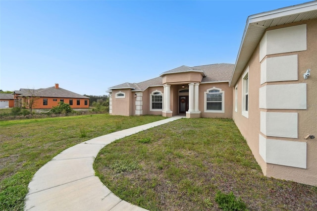 view of front facade featuring stucco siding and a front yard