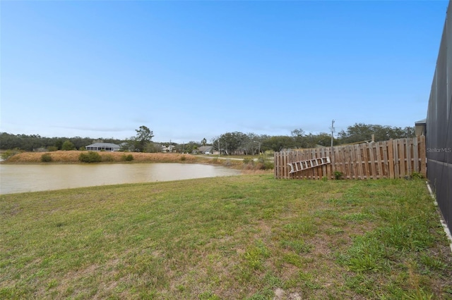 view of yard featuring fence and a water view