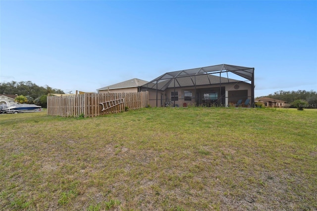 view of yard featuring a lanai and fence