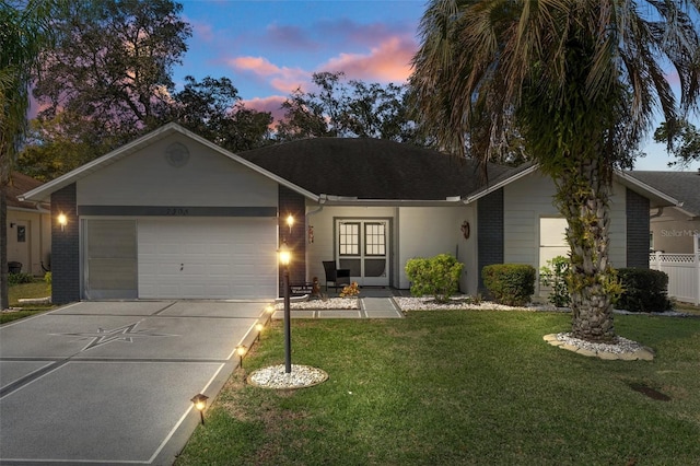 single story home featuring brick siding, fence, concrete driveway, a front yard, and an attached garage