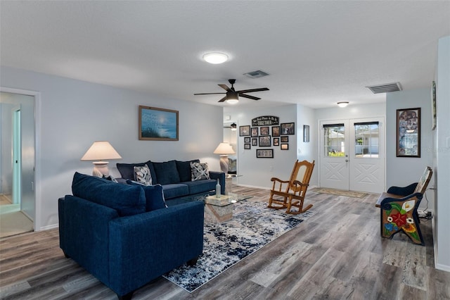 living room featuring wood finished floors, visible vents, and baseboards