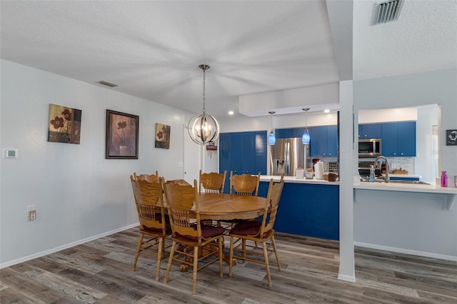 dining room featuring visible vents, a textured ceiling, and dark wood-type flooring