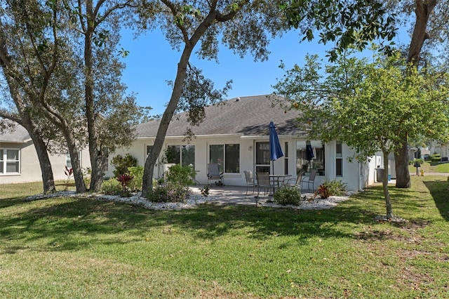 back of house with a yard, a patio, and stucco siding