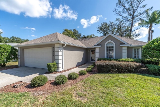 ranch-style home with a front lawn, concrete driveway, roof with shingles, stucco siding, and a garage